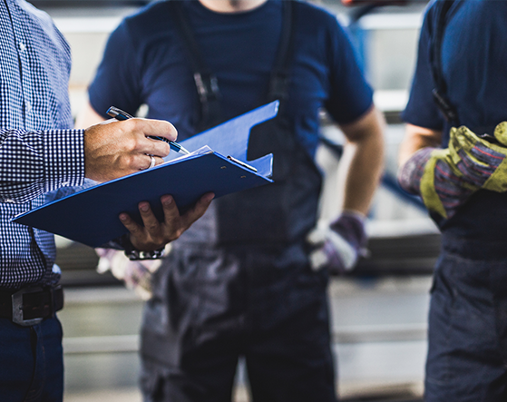 An assessor checking the work of two apprentices