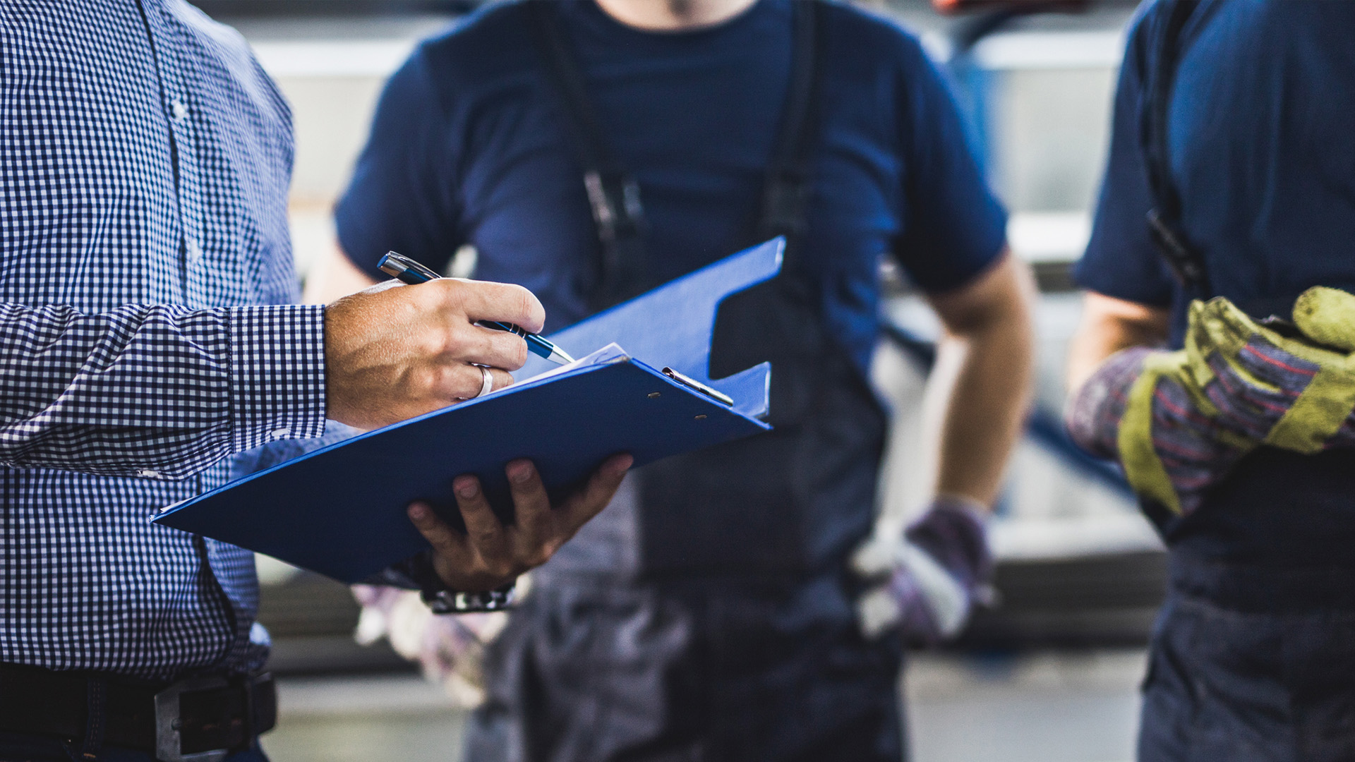 An assessor checking the work of two apprentices
