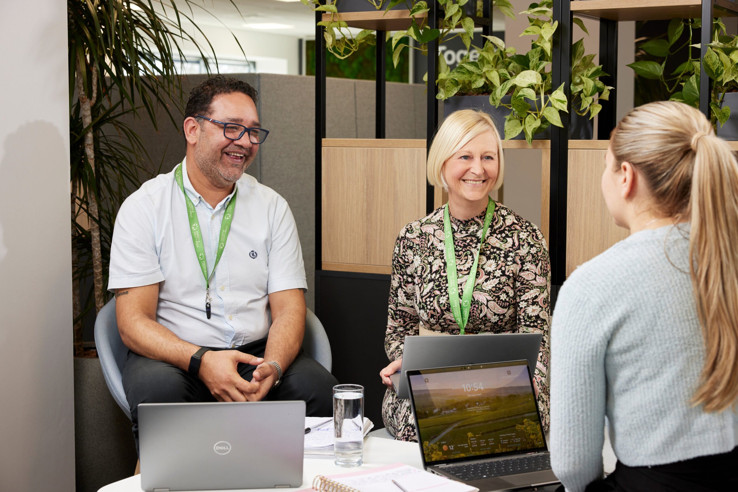 Colleagues who work at Energy & Utility Skills sitting together smiling.