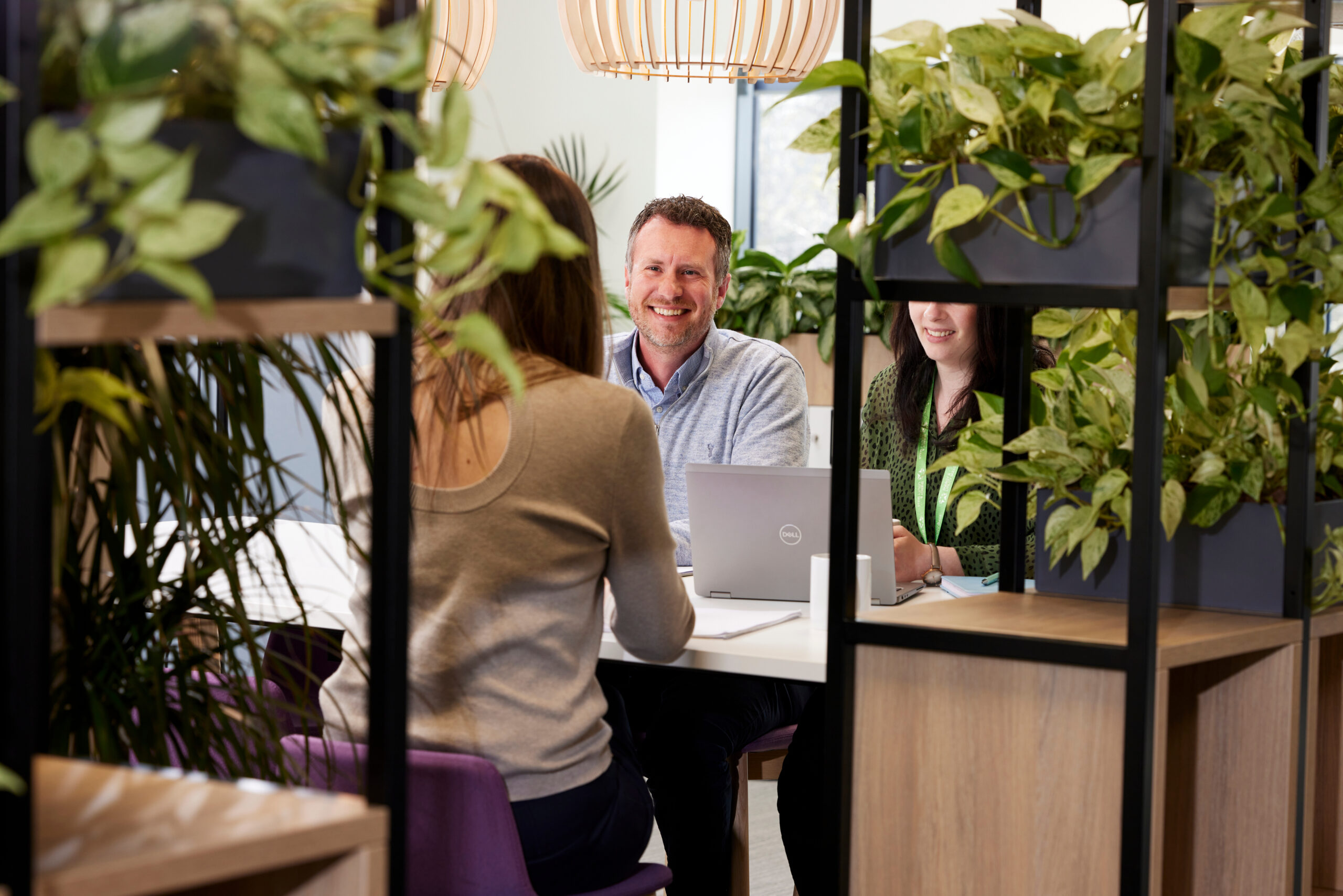 Colleagues at Energy & Utility Skills sitting at a table with plants around them.