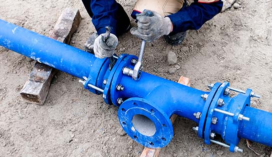 Workers installing water supply pipeline system, close up