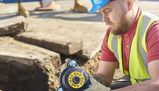a gas engineer holds a new gas valve as he prepares to replace the old pipework in a residential uk street .