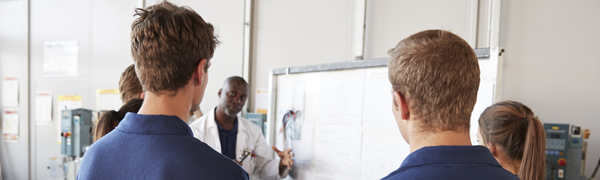 young people gathered around a white board